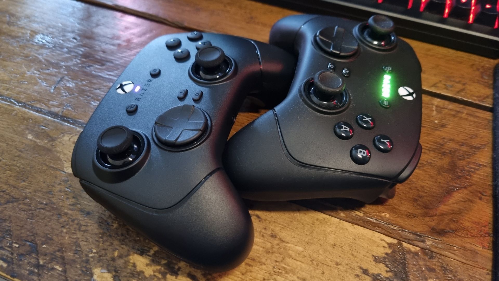 A Razer Wolverine V4 Pro nestled within the embrace of a Razer Wolverine V3 Pro. Aww.