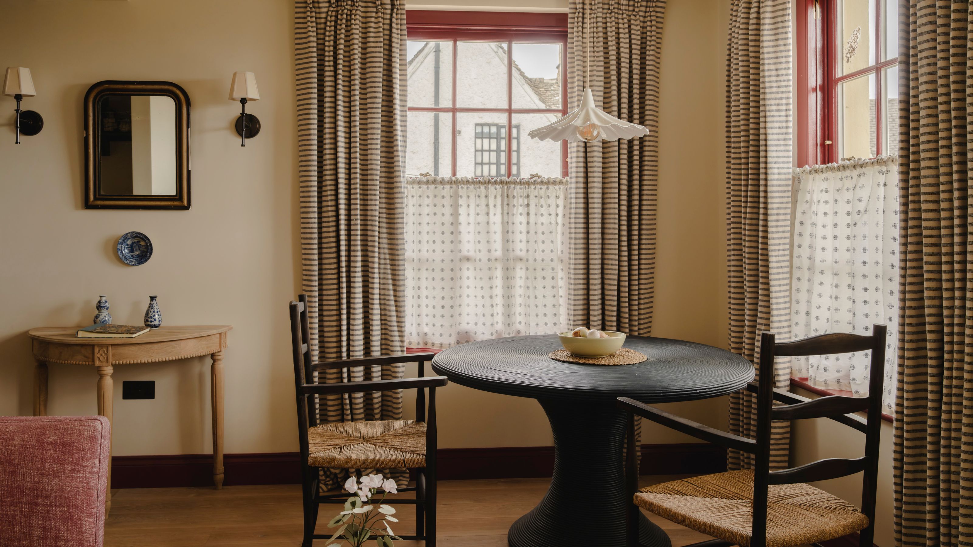 a warm apartment in the Cotwolds with red sash windows and a small breakfast nook