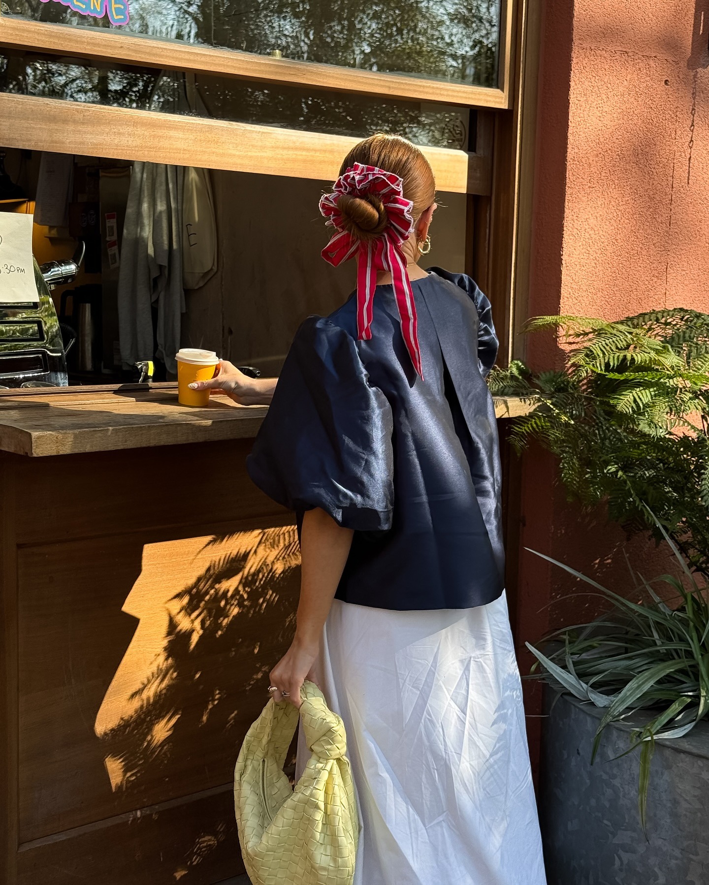 @rebeccaferrazwyatt wearing a slicked-back bun hairstyle with a large red scrunchie