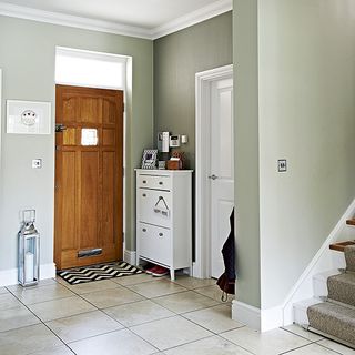 hallway with grey wall and stair case with tiles floor