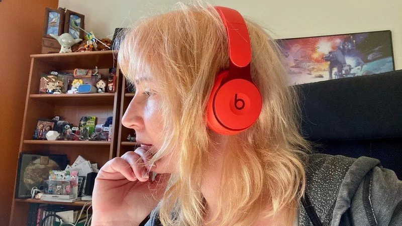 Wearing the red Beats Solo Pro headphones.