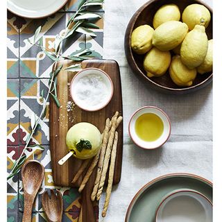 tiles dining table with lemons and salts and salad servers