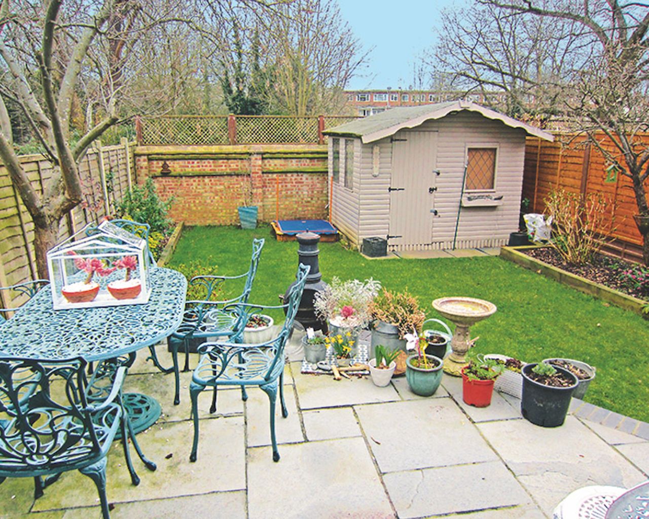 before shot of a garden with a lawn a shed and empty patch at the bottom of the garden