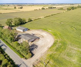 A plot next to a road and a large field