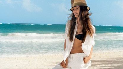 girl in white pants and black bikini on beach