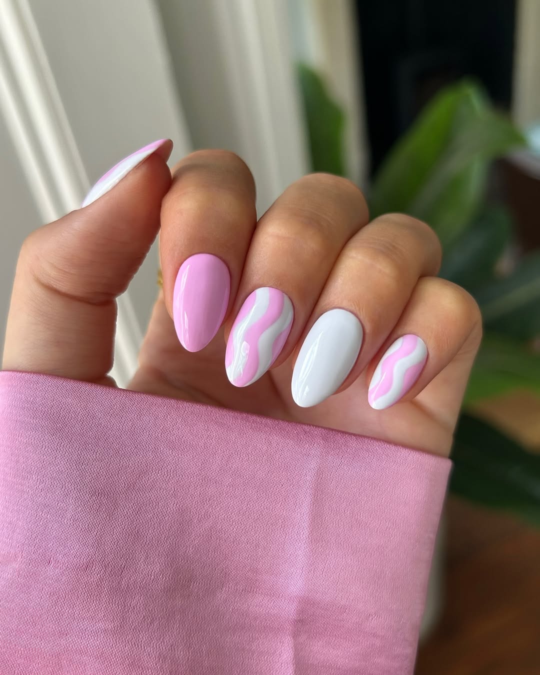 pink and white nails with a pink squiggle
