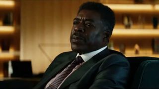 Ernie Hudson sits at his desk while telling a story in Ghostbusters: Afterlife.