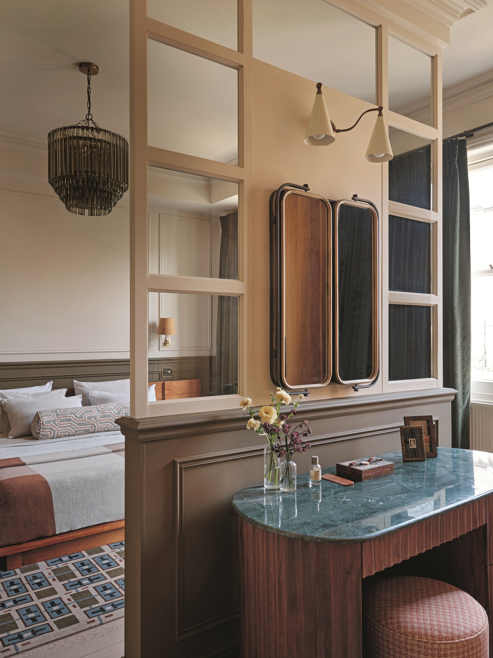 a bedroom with a wall divider with a vanity in between