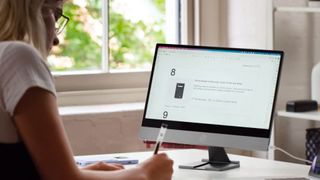 The Espresso portable display being used on a desk with a woman nearby writing notes.