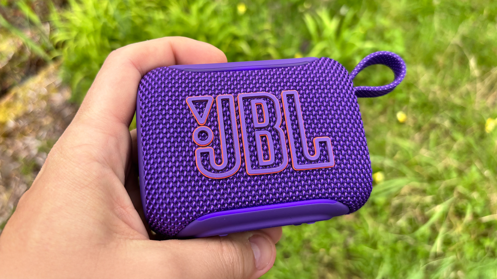 JBL Go 5 speaker in purple finish held in hand
