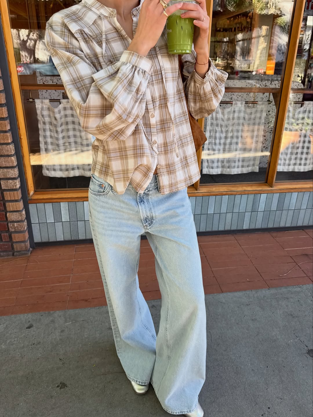 A woman wearing long and loose jeans, one of the rich-looking spring denim trends 2026.