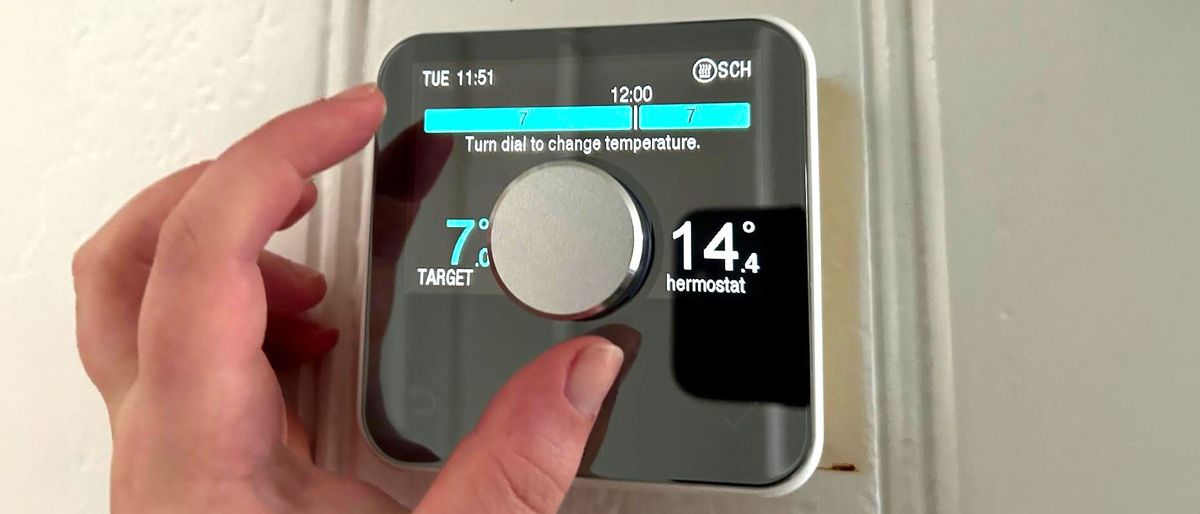 Person&#039;s hand controlling Hive Smart Thermostat manually