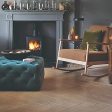 A living room colour drenched in dark grey, including the fireplace surrounding alit wood burning stove