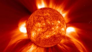 Image of coronal mass ejections, large wispy orange flares emitted from the sun.