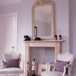 bedroom with armchairs and wall mirror