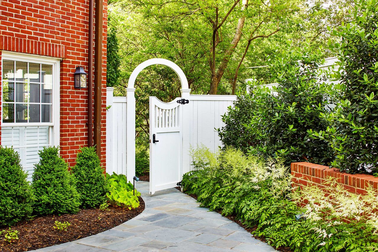 a side yard with a path and mulched gardens