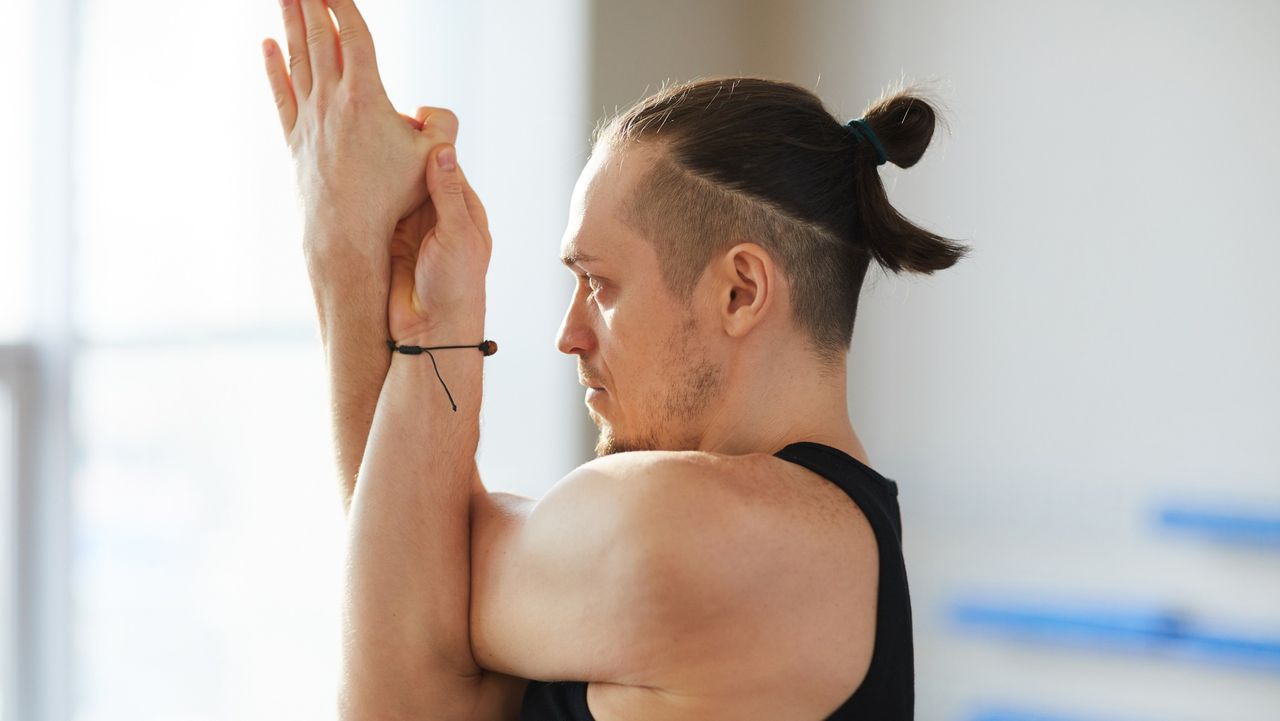 Man doing eagle stretch.