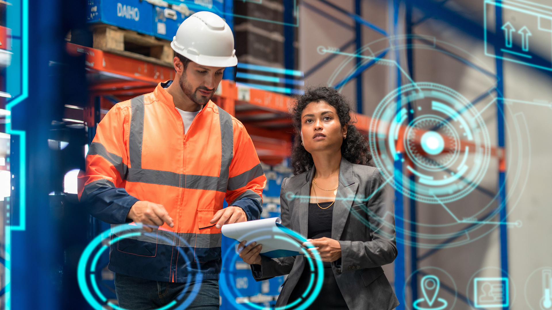 A photo of a warehouse worker and a supervisor depicting supply chain metrics, shown as blue holograms.