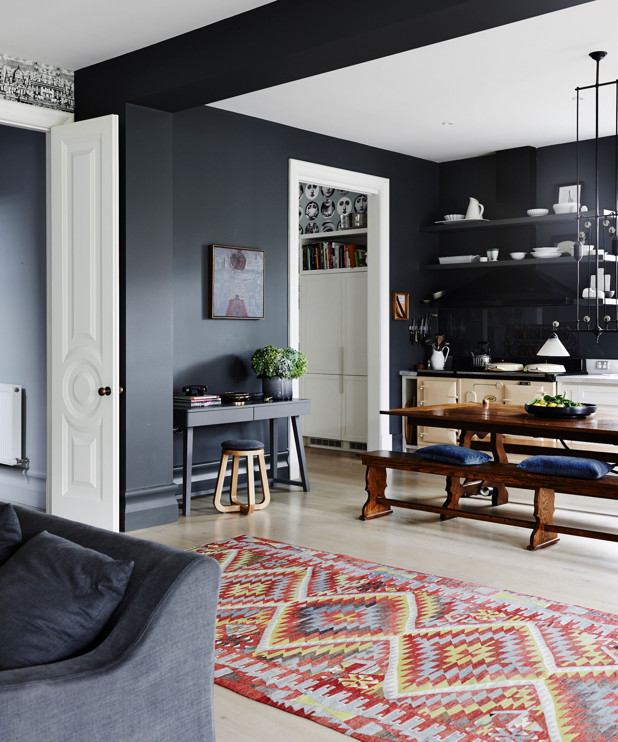 Open plan living with blue walls, wood floor and cream kitchen cabinets