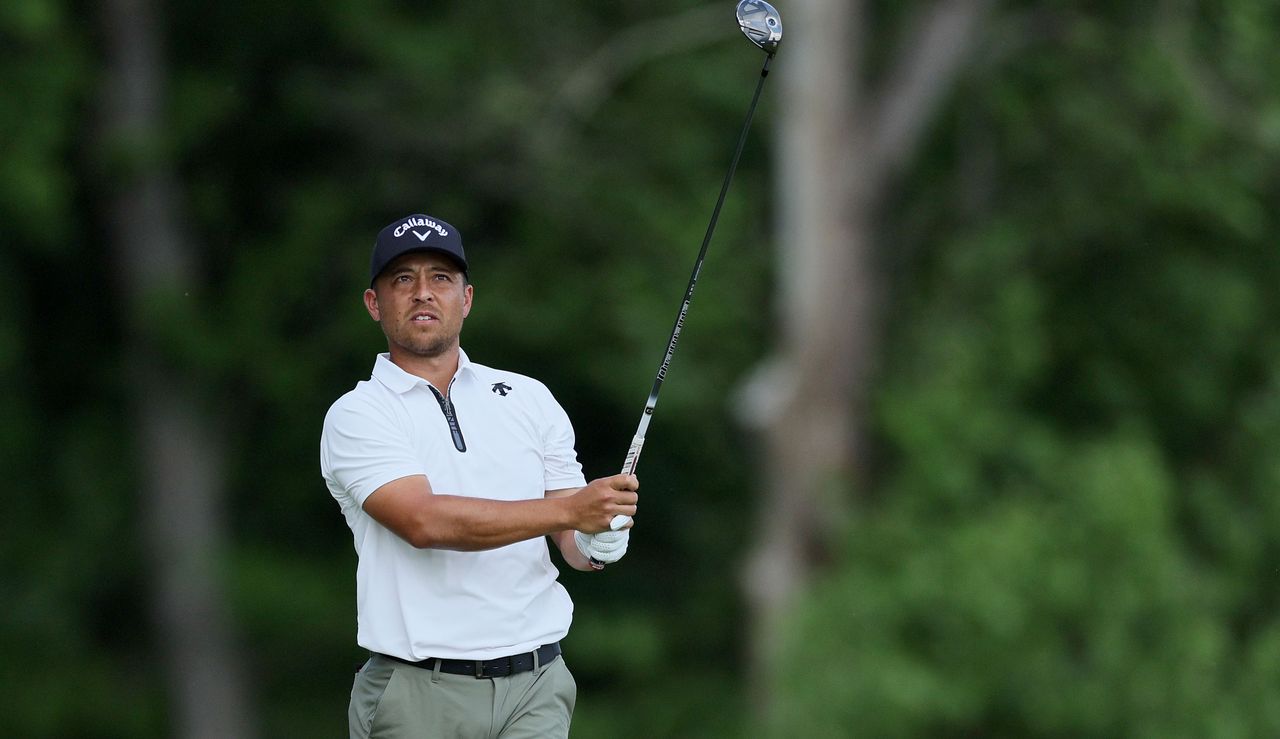 Xander Schauffele strikes a fairway wood and watches its flight