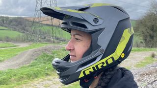 A rider wearing a Giro Insurgent Spherical full-face helmet with bike park backdrop 