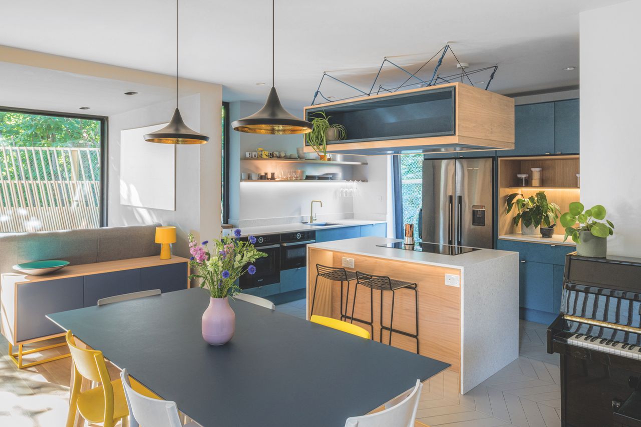 open plan kitchen and dining area with wood accents and modern lighting