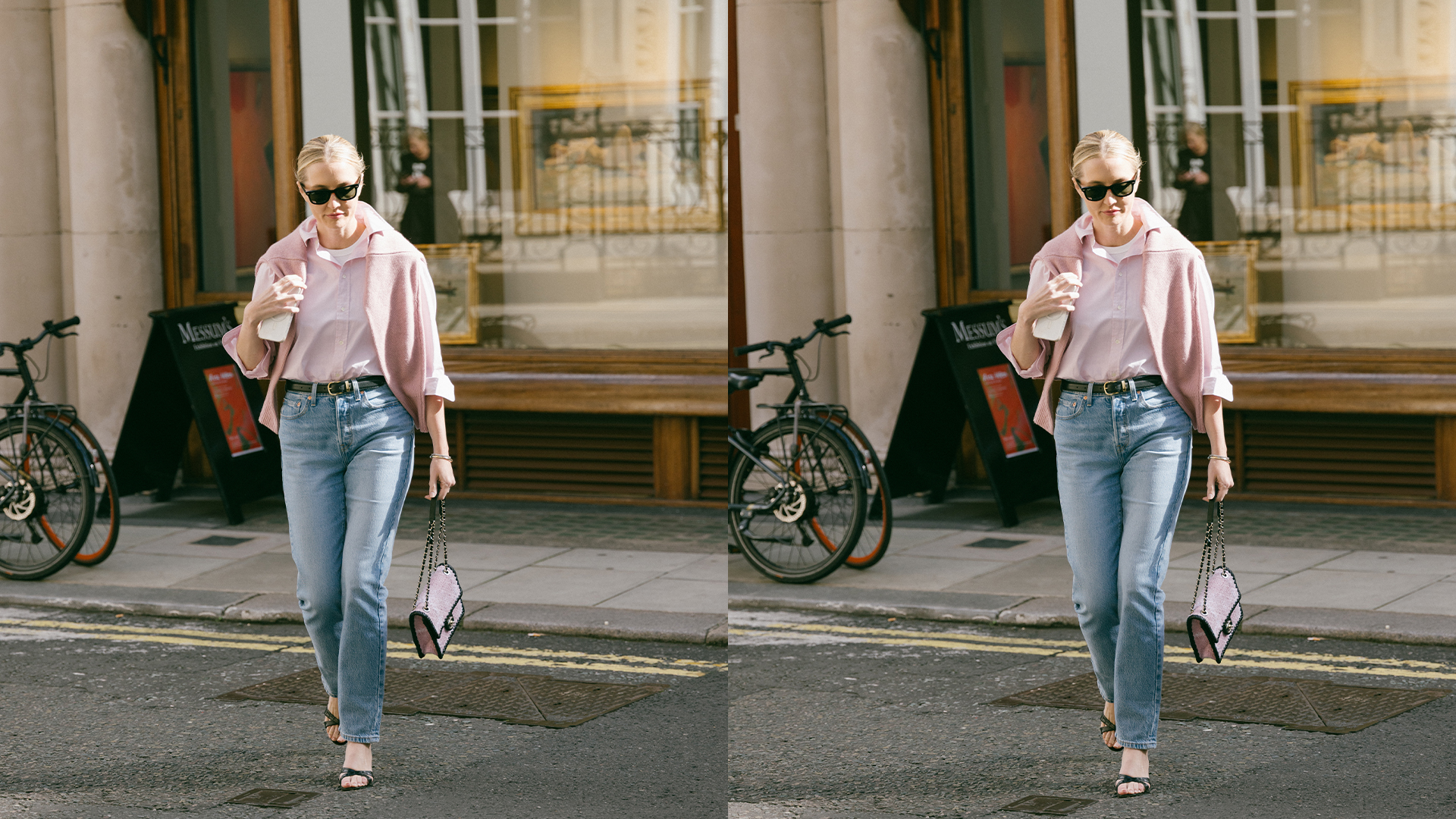Kristen walks on London street in pink button down, jeans, heels, handbag, and a sweater over her shoulders. 
