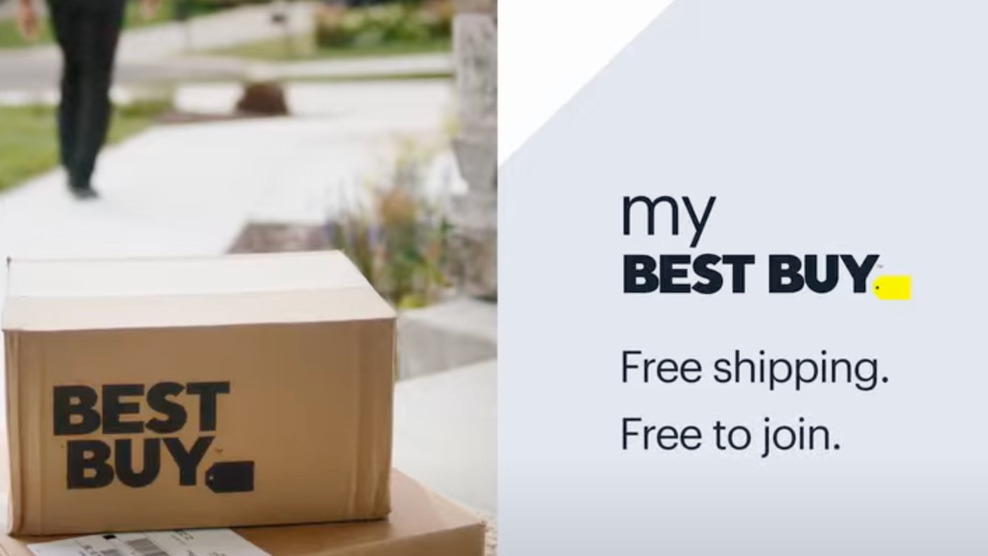 A promotional graphic for My Best Buy features the benefits &quot;Free shipping&quot; and &quot;Free to join&quot; on a gray background next to a stack of Best Buy boxes on a doorstep with a person walking away in the background.