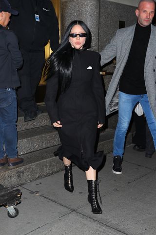 Lady Gaga leaving Radio City Music Hall with security on Feb. 13 wearing an all-black outfit and bleached eyebrows.