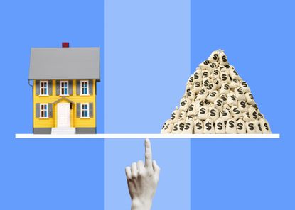 Miniature model of yellow single family home and a pile of money bags balancing on monochromatic woman's finger, striped blue background
