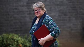 Thérèse Coffey, Secretary of State for Environment, Food and Rural Affairs, walking with a red binder under her arm