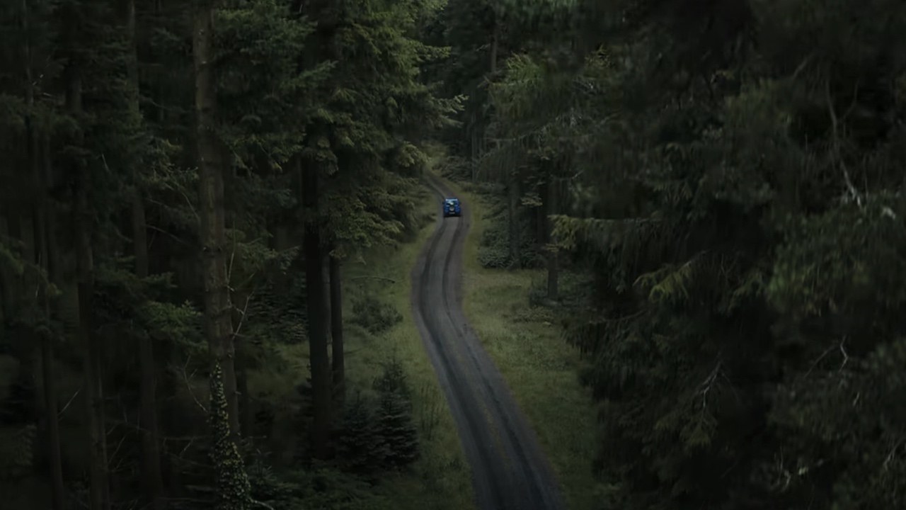 Mina's car driving down unpaved road through the forest in The Watchers
