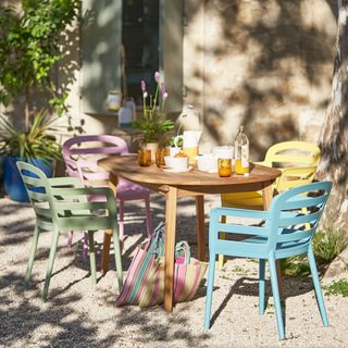 A set of colourful outdoor chairs around a garden dining table