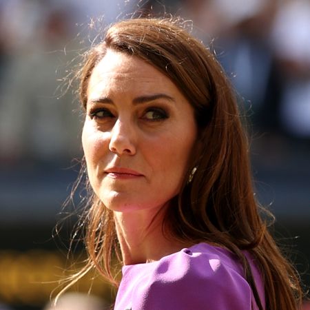 Kate Middleton has long brown hair and turns around at Wimbledon in 2024, where she is wearing a purple dress