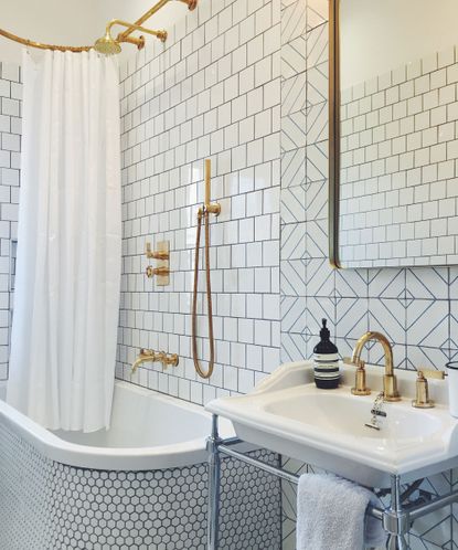 Trio tiled white bathroom with gilded accents and large mirror