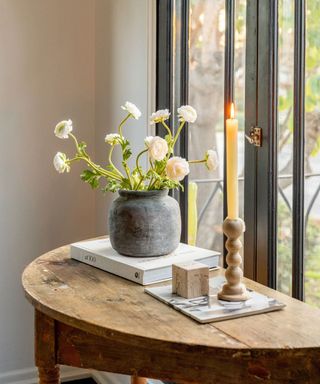 Easy Thanksgiving decor ideas. Vase of white flowers and candles on wooden table