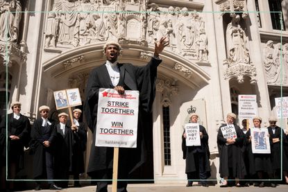 Striking barristers in their wigs and gowns holding placards reading 'strike together win together' 