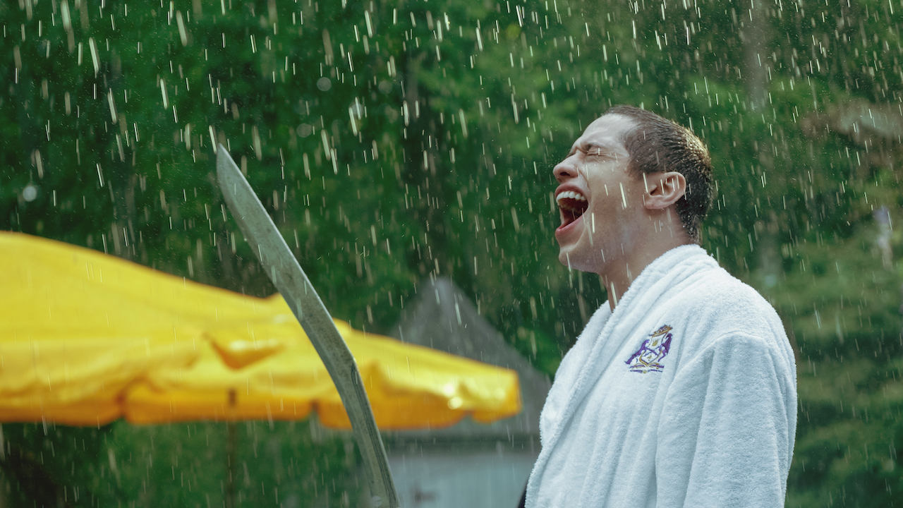 Pete Davidson sostiene una espada bajo la lluvia en Bodies Bodies Bodies
