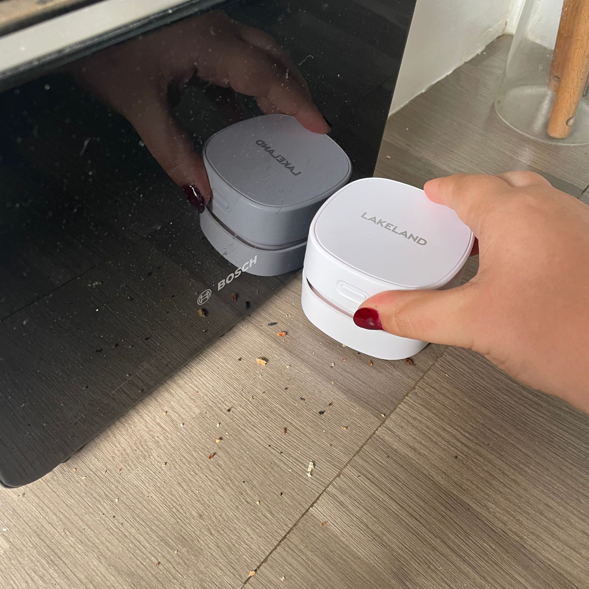 Lakeland mini countertop vacuum vacuuming toaster crumbs next to a black toaster