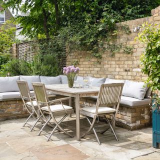 Patio area in the garden of an Edwardian Terraced House with wooden dining table and chairs