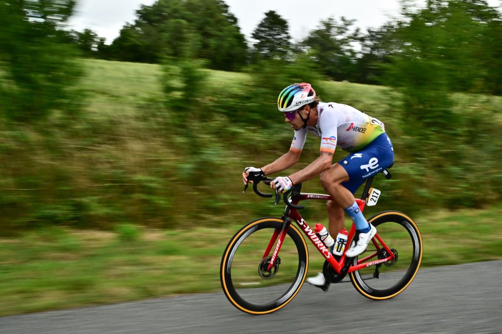 TotalEnergies' Italian rider Daniel Oss cycles in the rain, in a lone breakaway ahead of the pack of riders during the 11th stage of the 110th edition of the Tour de France cycling race, 180 km between Clermont-Ferrand and Moulins, in central France, on July 12, 2023. (Photo by Marco BERTORELLO / AFP)