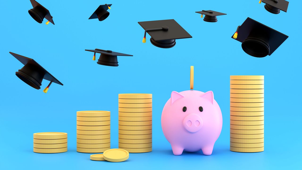 Stacks of coins and piggy bank for college students with graduation caps