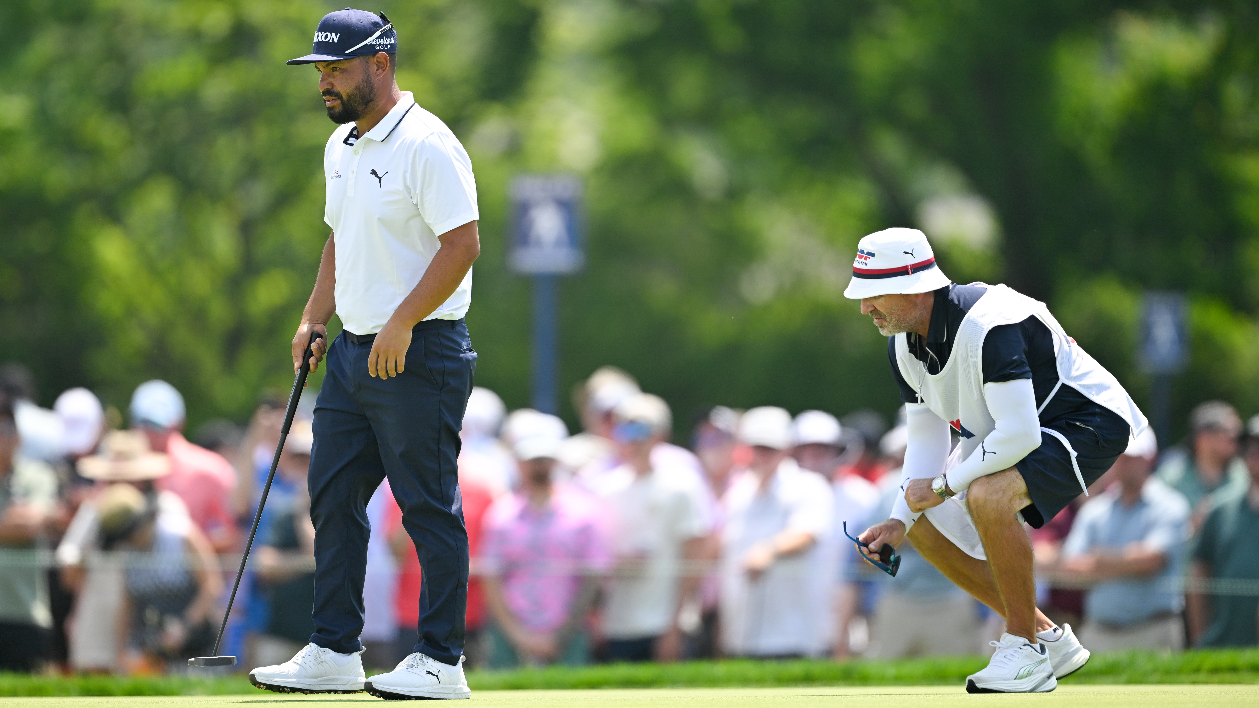 JJ Spaun and his caddie reading a putt on the eight hole at the 2025 US Open