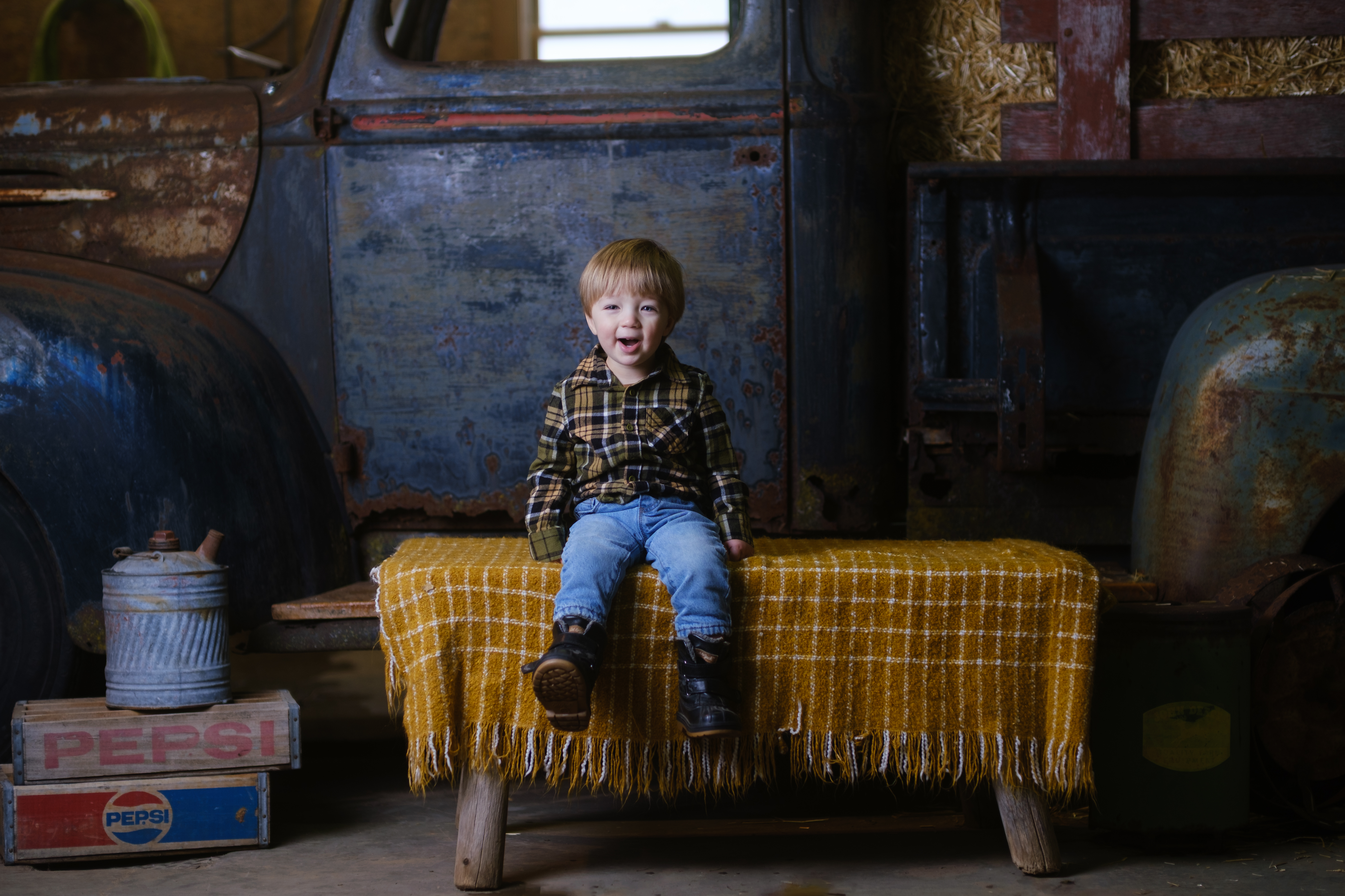 A toddler in a farm portrait setup