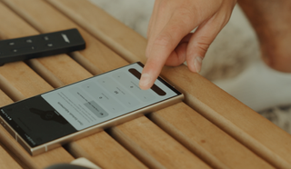 A man adjusts the center channel and 'rear speakers' in the Bose app