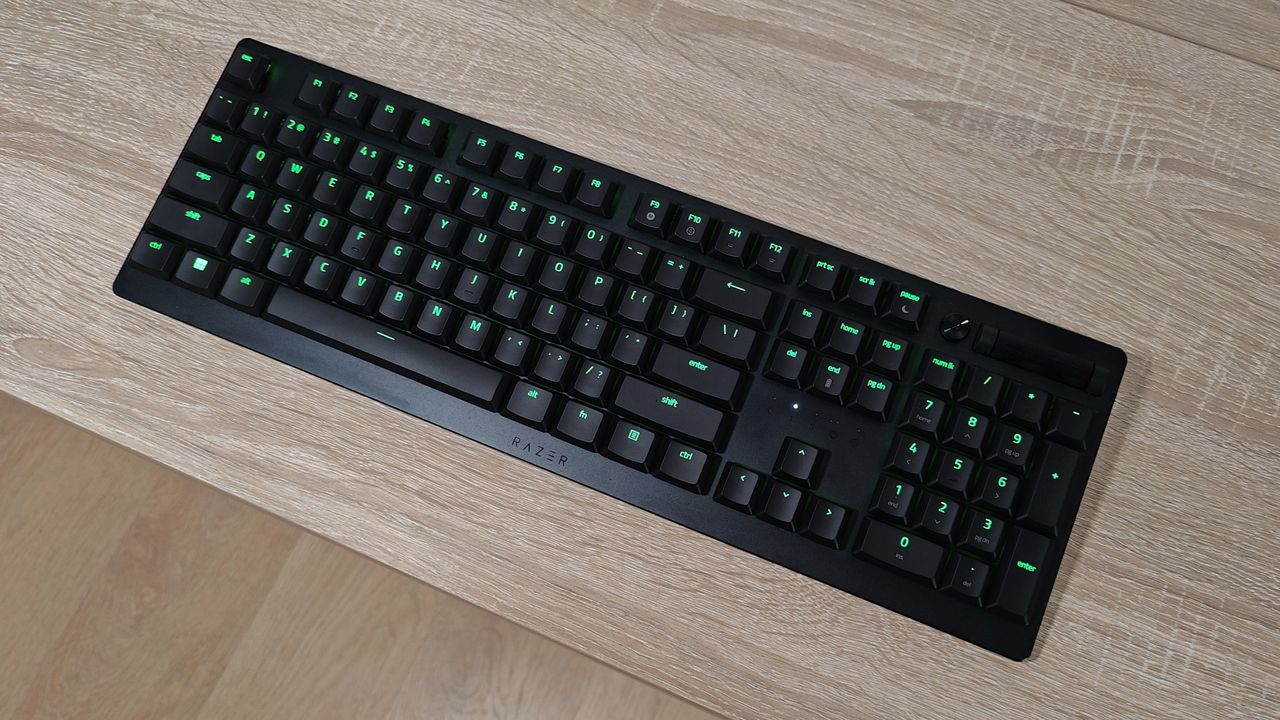 Razer Deathstalker V2 Pro review: keyboard on a wooden desk with lights on the keys