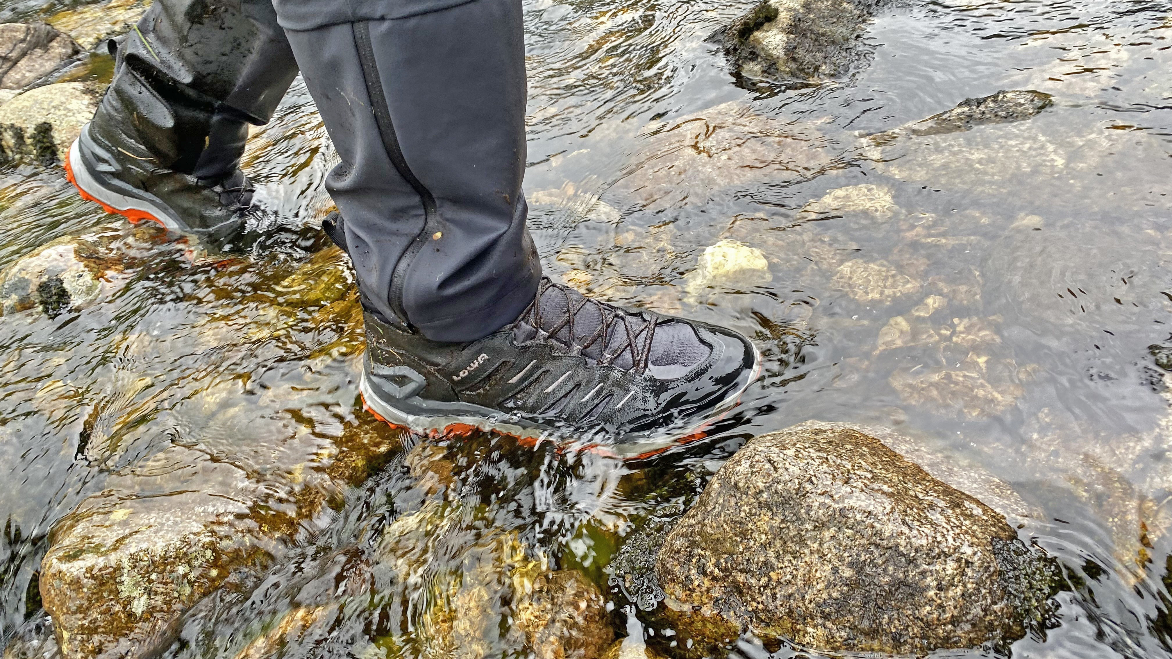 Hiker wearing the Lowa Innovo Mid GTX hiking boots during a stream crossing