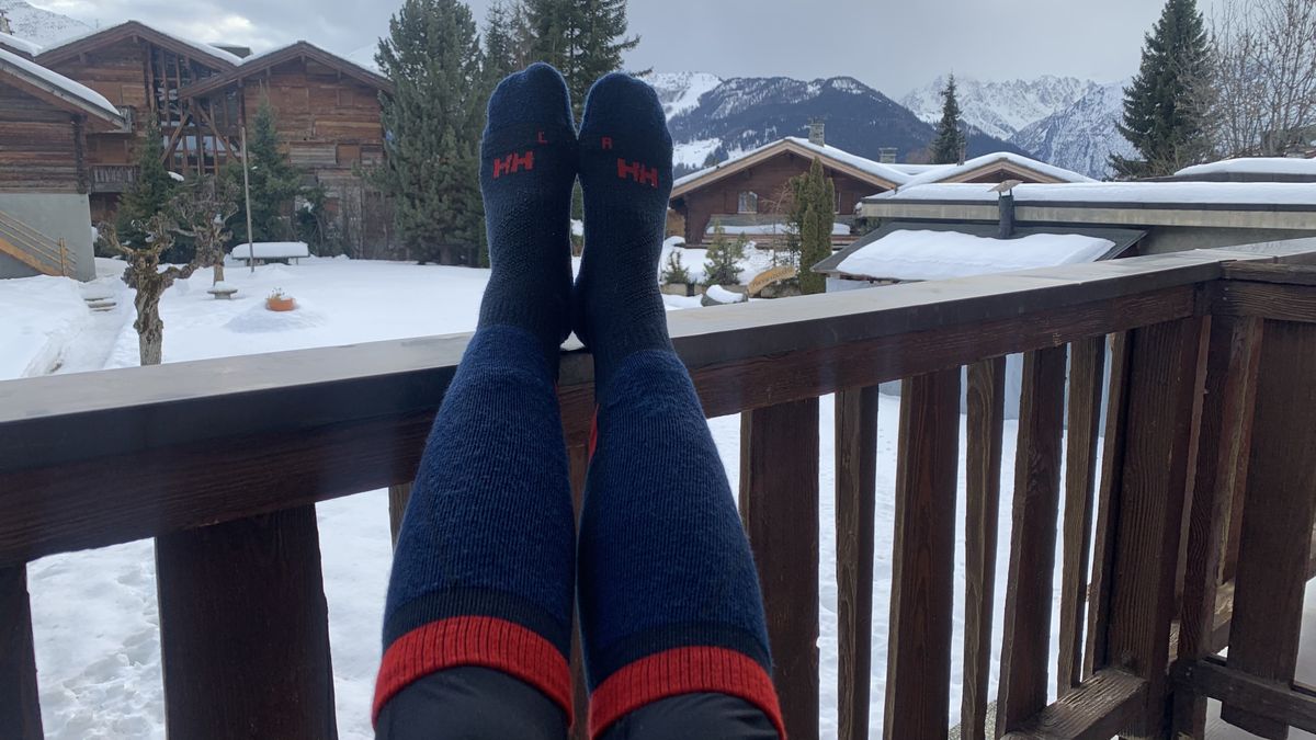 Skier puts their feet up on a balcony at a ski resort