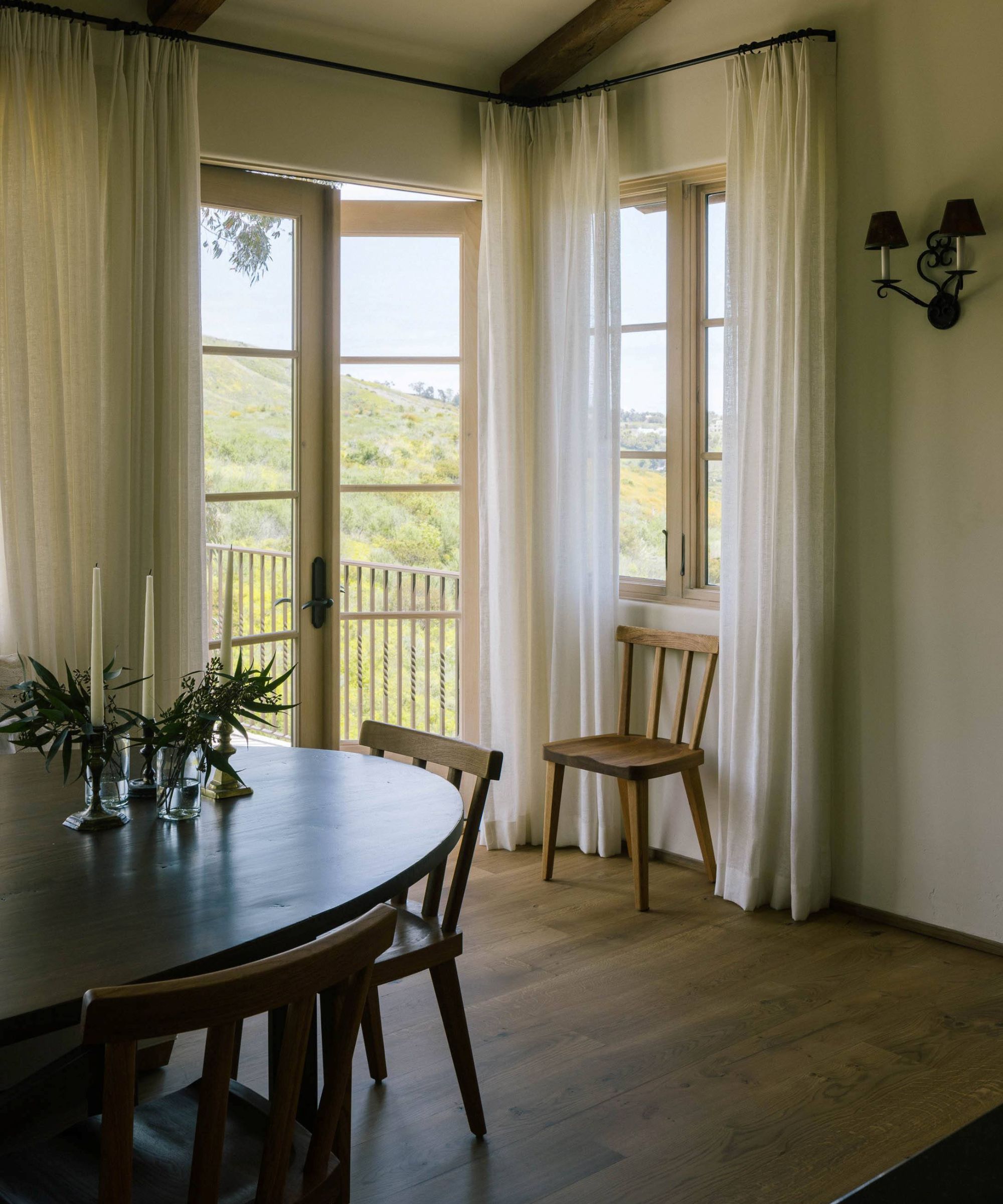 a Spanish style dining room with patio doors and vintage wooden furniture