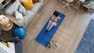 Woman working out on yoga mat at home as part of exercise snacking